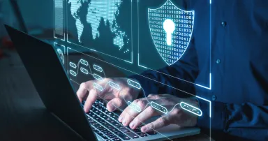 laptopon dolgozó ember körülötte kibervédelemre utaló ikonok