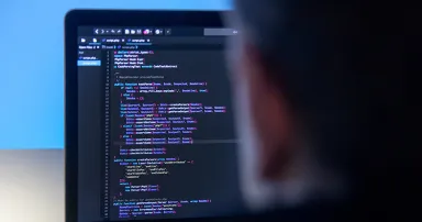 Web Coder working on laptop computer in office