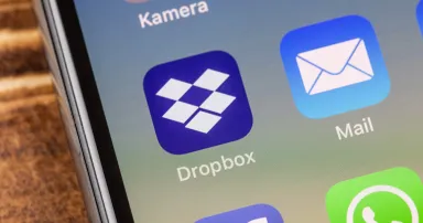 Close up to dropbox app on the screen of an iPhone X with personalized background