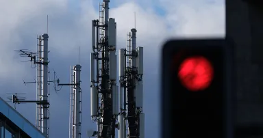 <p>A traffic light shows red under a cellular phone tower that stands on top of an office building on Jan. 2, 2019, in Berlin. (Photo by Sean Gallup/Getty Images)</p>