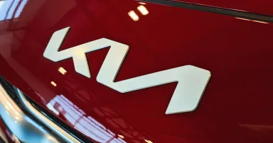 KIA Motors logo sign on car of red color