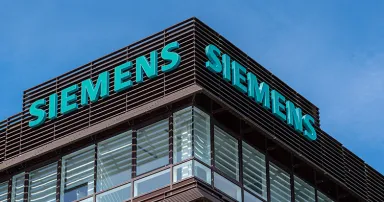 A sign on top of a building reads "Siemens" in blue letters.