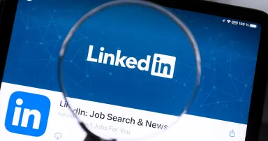 Linkedin app under a magnifying glass.