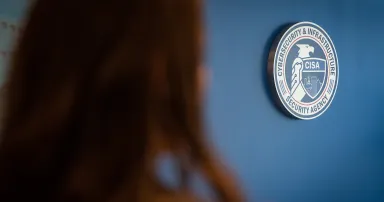 The CISA logo is seen hanging on a blue wall