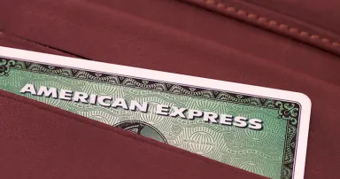 The top of an American Express Card is exposed in a leather wallet