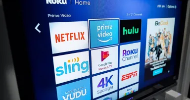 A consumer in a home using a modern smart television to stream various content.