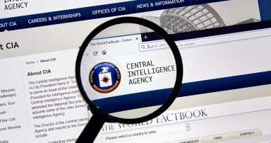 Cia.gov USA Government home page under magnifying glass. Cia.gov is Central Intelligence Agency official web page.