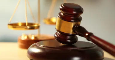 Wooden judges gavel on wooden table, close up