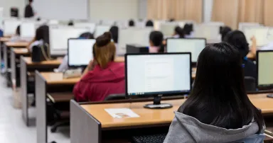 Blur and selective focus of the university student using computer studying in computer room. Group of students in study in computers room.