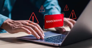 Malware attack virus alert. Person use laptop with virtual warning sign with ransomware word. warning notification, Cyber threats.