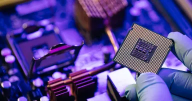 Engineer showing a computer microchip on motherboard background. Electronic circuit board with processor.