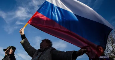 A woman waves a Russian flag