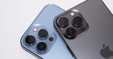 Close up the triple-lens camera on the iPhone 13 Pro Max Seirra Blue and Graphite Color on white background.