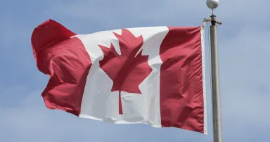 The Canadian flag flies on a flagpole