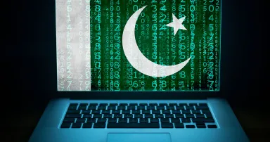 Pakistan internet security. Laptop with binary computer code an