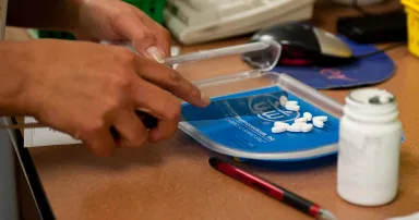 A pharmacy technician counts pills to fill a prescription.