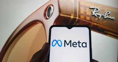 Meta logo on smartphone screen with Ray-Ban smart glasses