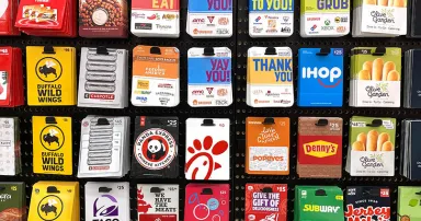 Multiple types of fast food and restaurant gift cards displayed on stand. Including Panda Express, Chick-fil-A, Taco Bell, IHOP, Chipotle, Subway - California, USA - 2023