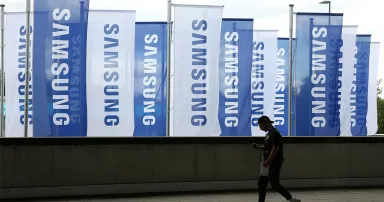 An employee passes Samsung flags