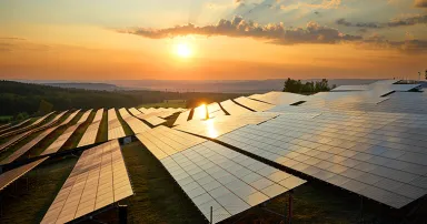 Photovoltaic panels of solar power station in the landscape at sunset. View from above.
