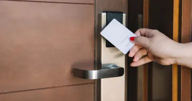 Young woman opening hotel room electronic lock with key card