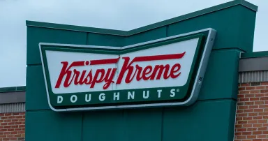Closeup of Krispy Kreme restaurant sign on the building.