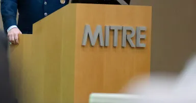 A speaker presents at the MITRE Corporation in Bedford, Mass. (Air Force)