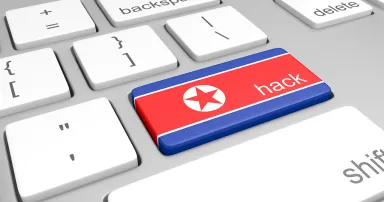 North Korea hacking concept of a computer keyboard and a key painted with the North Korean flag