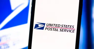 Smartphone with the USPS logo on the screen. United States Postal Service app.