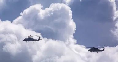 Military Helicopters flying through Storm Clouds