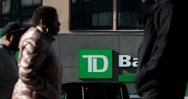 <p>People walk past a TD Bank in the Brooklyn borough of New York City. Earlier this month, a federal grand jury indicted three men for their alleged role in a business email compromise scam, including a former employee of both TD Bank and Bank of America. (Photo by Drew Angerer/Getty Images)</p>
